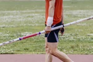 Male athlete holding pole vault pole