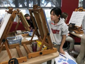 Art student painting on canvas