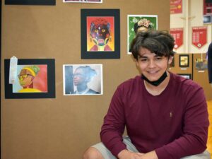 Male art student posing with art and ribbon