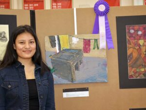 Art student posing with her art and ribbon