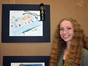 Art student posing with her art and ribbon