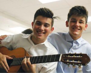 Two male students using guitars