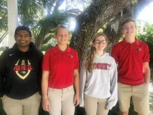 Four students standing in line to pose for picture